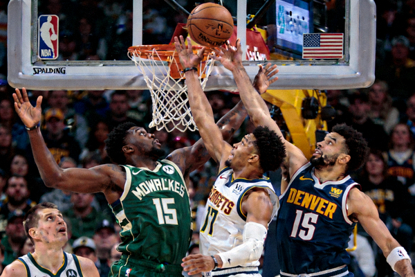 密尔沃基雄鹿队与丹佛掘金队的NBA比赛精彩瞬间，双方球员在篮下激烈争抢篮板球