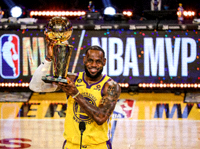 NBA球员在领奖台上手举MVP奖杯的新闻图片，现场灯光璀璨